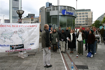 71. LYM chorus in outdoor mall from conductor's right, banner almost fully in view on left